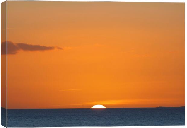 The sun setting over the horizon with an orangey in the sky Canvas Print by Rory Hailes