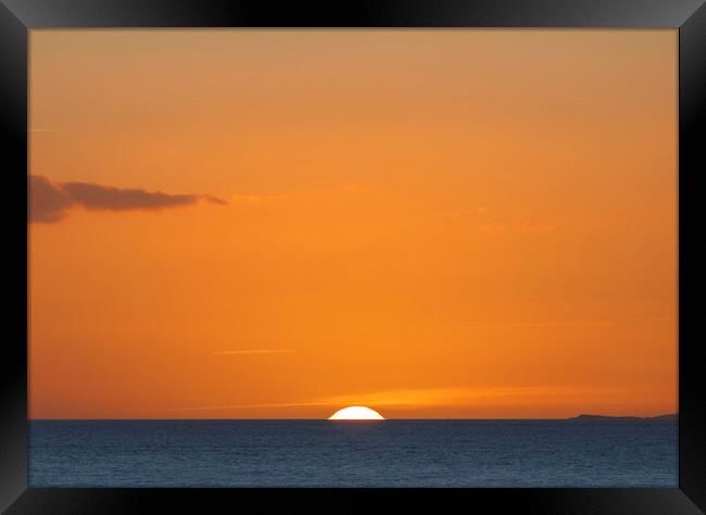 The sun setting over the horizon with an orangey in the sky Framed Print by Rory Hailes