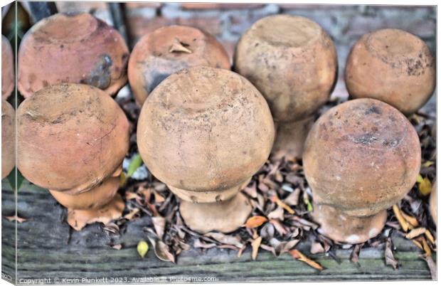 A close up of a pile of upside clay pots Canvas Print by Kevin Plunkett