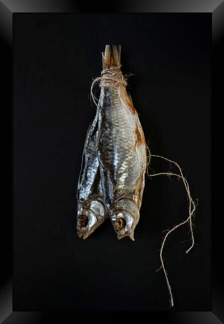 Traditional dried fish on a black background.  Framed Print by Olga Peddi