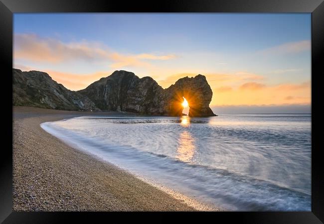 Sunrise through the arch of Durdle Door Dorset  Framed Print by Shaun Jacobs