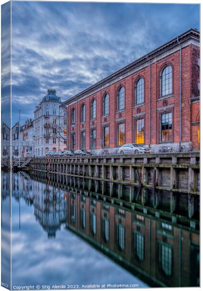 buildings in Nyhavn are reflected in the water during the blue h Canvas Print by Stig Alenäs