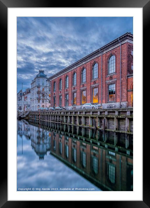 buildings in Nyhavn are reflected in the water during the blue h Framed Mounted Print by Stig Alenäs