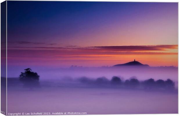 Glastonbury Tor in morning mist Canvas Print by Les Schofield