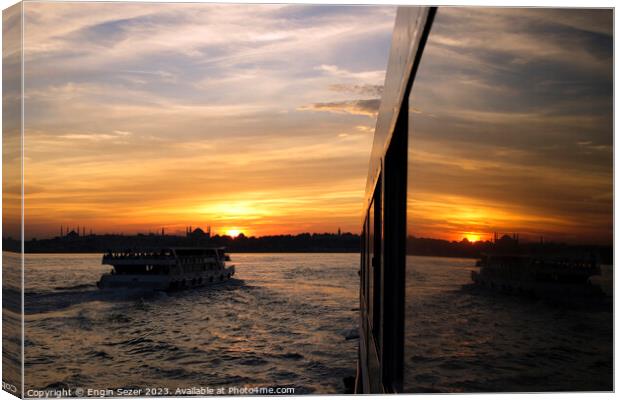 A sunset in Istanbul with the reflections on a boats windows 2 Canvas Print by Engin Sezer