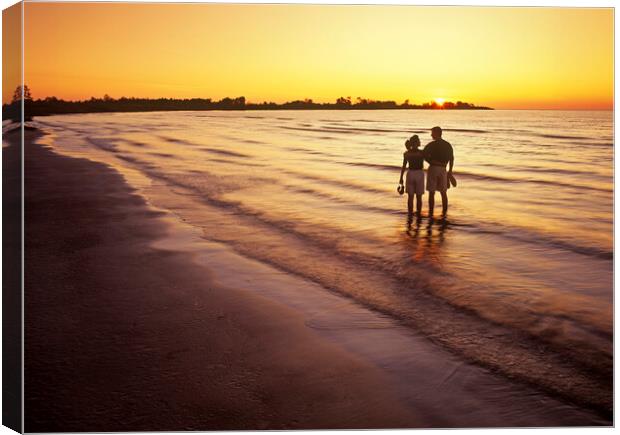 couple along beach at sunset Canvas Print by Dave Reede