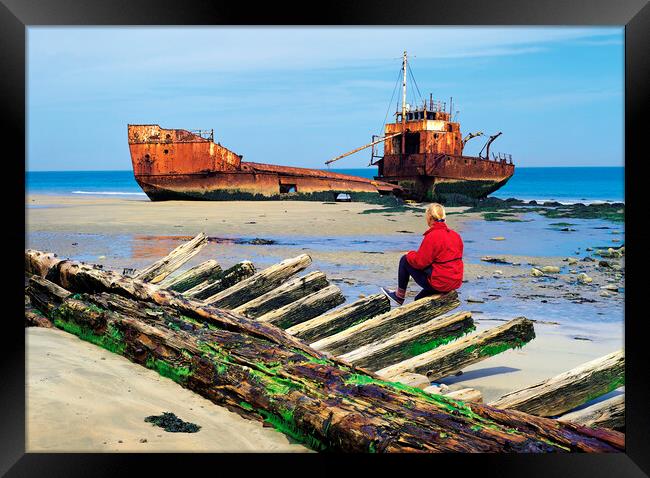 woman sitting on remains of wooden shipwreck viewing shipwreck Framed Print by Dave Reede
