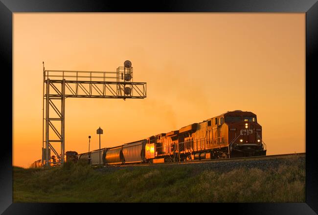locomotives pulling rail hopper cars pass an overhead rail signal Framed Print by Dave Reede