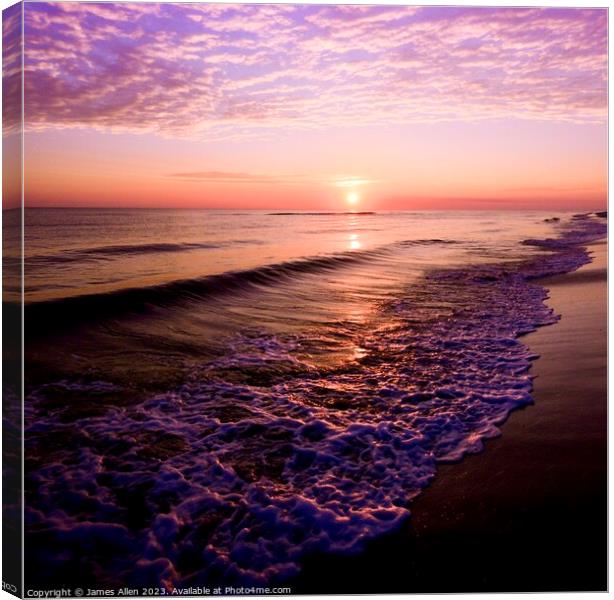 A sunset over a beach next to the ocean Canvas Print by James Allen