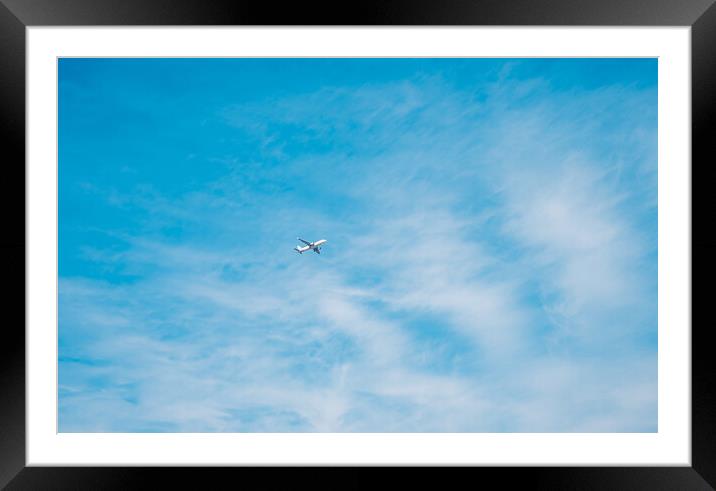 aircraft flying through a cloudy blue sky Framed Mounted Print by Ambir Tolang