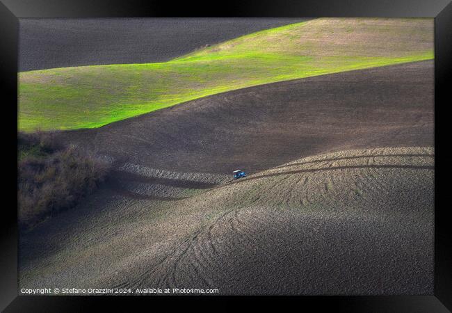 Tractor plowing the fields in Tuscany. Volterra, Italy Framed Print by Stefano Orazzini