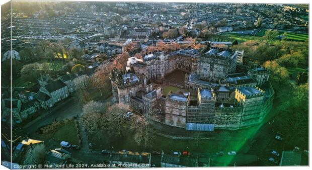 Aerial view of a historic Lancaster castle at sunset with surrounding greenery and urban backdrop. Canvas Print by Man And Life