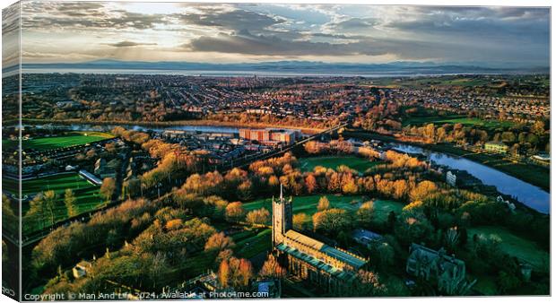 Aerial view of a cityscape at sunset with a prominent cathedral, lush green parks, and a river reflecting the warm sky in Lancaster. Canvas Print by Man And Life