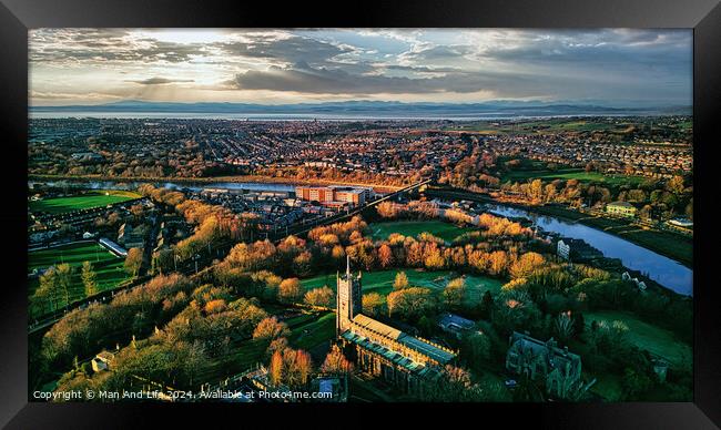 Aerial view of a cityscape at sunset with a prominent cathedral, lush green parks, and a river reflecting the warm sky in Lancaster. Framed Print by Man And Life