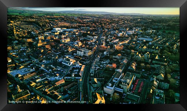 Aerial view of a cityscape at sunset with warm lighting, showcasing dense buildings and streets leading to the horizon in Lancaster. Framed Print by Man And Life
