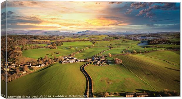 Aerial view of a picturesque village amidst green fields during sunset with a vibrant sky and a meandering river. Canvas Print by Man And Life