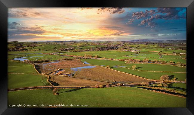 Aerial view of a picturesque rural landscape at sunset with vibrant skies, patchwork fields, and a network of country roads. Framed Print by Man And Life