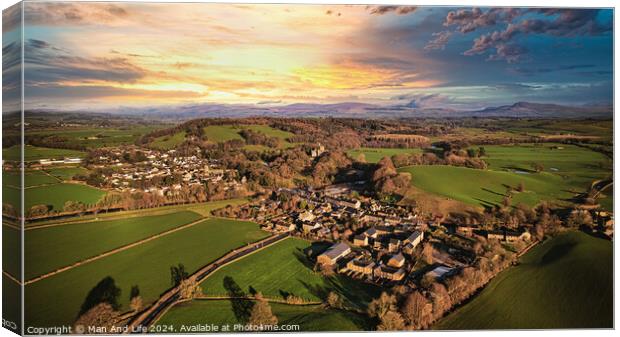 Aerial view of a quaint village amidst green fields during sunset with dramatic clouds. Canvas Print by Man And Life
