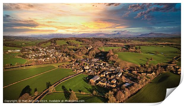 Aerial view of a quaint village amidst green fields during sunset with dramatic clouds. Print by Man And Life