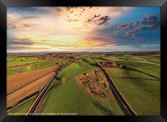 Aerial view of a lush countryside at sunset with vibrant skies and patchwork fields. Framed Print by Man And Life