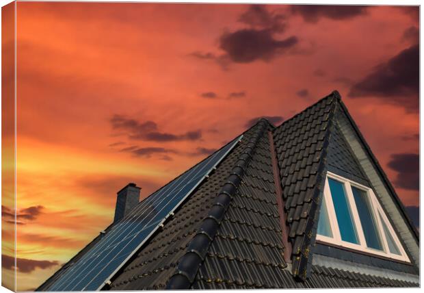 Solar panels producing clean energy on a roof of a residential house during sunset. Canvas Print by Michael Piepgras