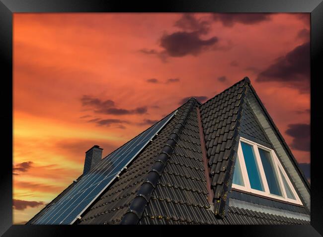 Solar panels producing clean energy on a roof of a residential house during sunset. Framed Print by Michael Piepgras
