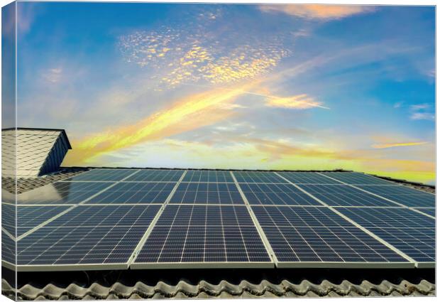 Solar panels producing clean energy on a roof of a residential house during sunset. Canvas Print by Michael Piepgras
