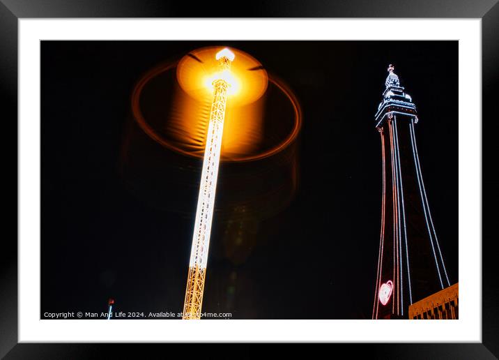 Illuminated street lamp and tower at night with a glowing halo effect and dark sky. Framed Mounted Print by Man And Life