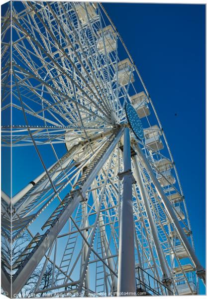 Low-angle view of a Ferris wheel against a clear blue sky in Lancaster. Canvas Print by Man And Life
