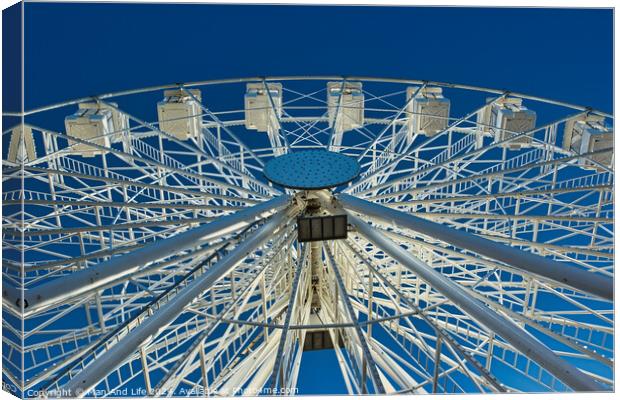 Ferris wheel against a clear blue sky, symmetrical view from below in Lancaster. Canvas Print by Man And Life