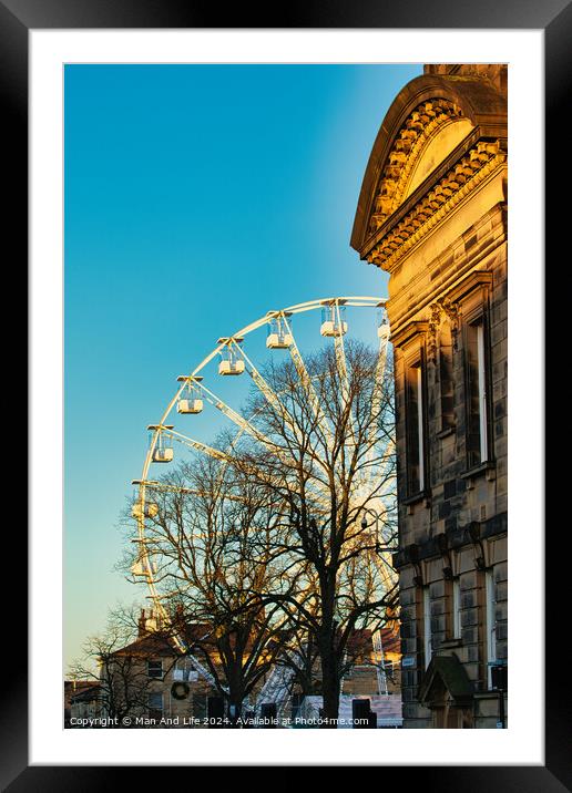 Historic building corner with a Ferris wheel and tree silhouettes against a clear blue sky at sunset in Lancaster. Framed Mounted Print by Man And Life
