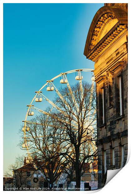 Historic building corner with a Ferris wheel and tree silhouettes against a clear blue sky at sunset in Lancaster. Print by Man And Life