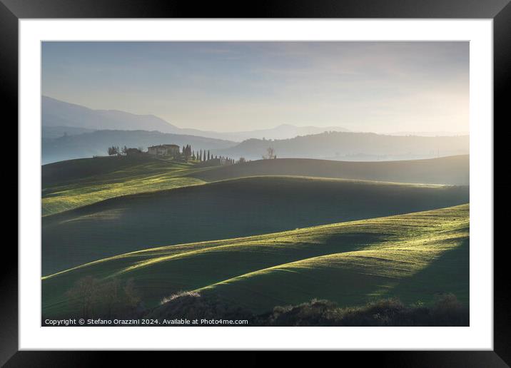 Landscape in Val d'Orcia with farmhouse and rolling hills. Tuscany Framed Mounted Print by Stefano Orazzini