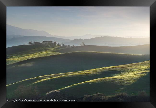 Landscape in Val d'Orcia with farmhouse and rolling hills. Tuscany Framed Print by Stefano Orazzini