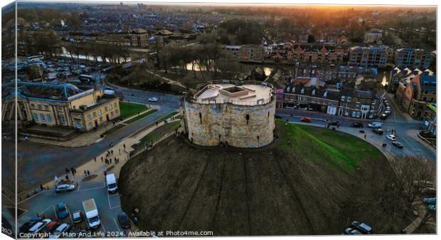 Aerial view of a historic circular stone fortress at dusk, with surrounding urban landscape and sunset sky in York, North Yorkshire Canvas Print by Man And Life