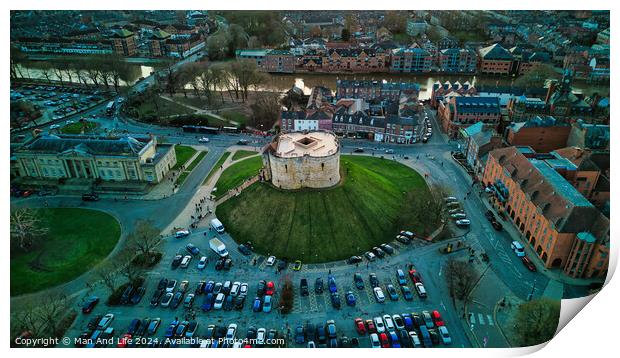 Aerial view of a historic building with a circular shape surrounded by a green lawn, parking area, and cityscape during twilight in York, North Yorkshire Print by Man And Life