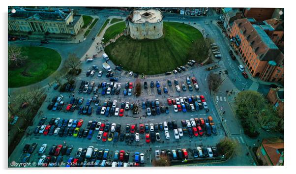 Aerial view of a circular building surrounded by a parking lot with colorful cars, showcasing urban planning and architecture in York, North Yorkshire Acrylic by Man And Life