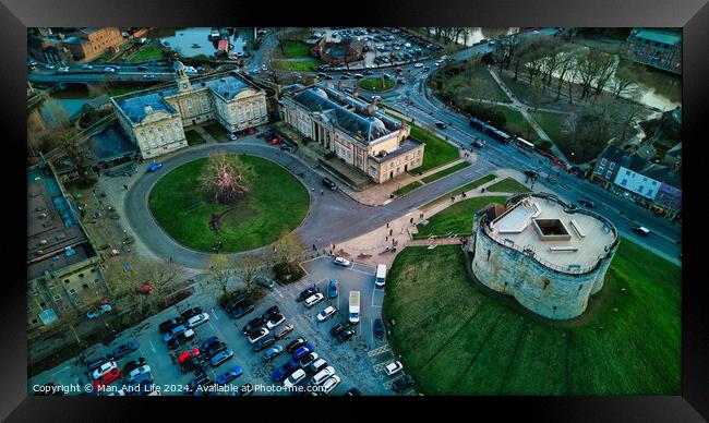 Aerial view of a historic cityscape with a roundabout, ancient buildings, and a fortress at dusk in York, North Yorkshire Framed Print by Man And Life