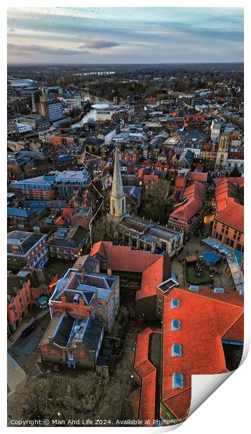 Aerial view of a historic town at dusk with prominent church spire and terracotta rooftops against a moody sky in York, North Yorkshire Print by Man And Life