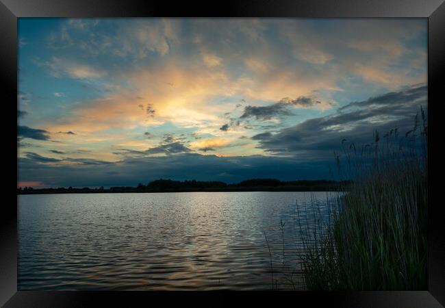 Clouds after sunset over the lake with reeds Framed Print by Dariusz Banaszuk