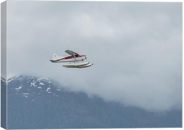 DeHavilland DHC-2 Float Plane Flying low past cloud covered mountains Alaska, USA Canvas Print by Dave Collins