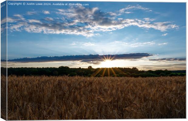 Setting sun over wheat field Canvas Print by Justin Lowe
