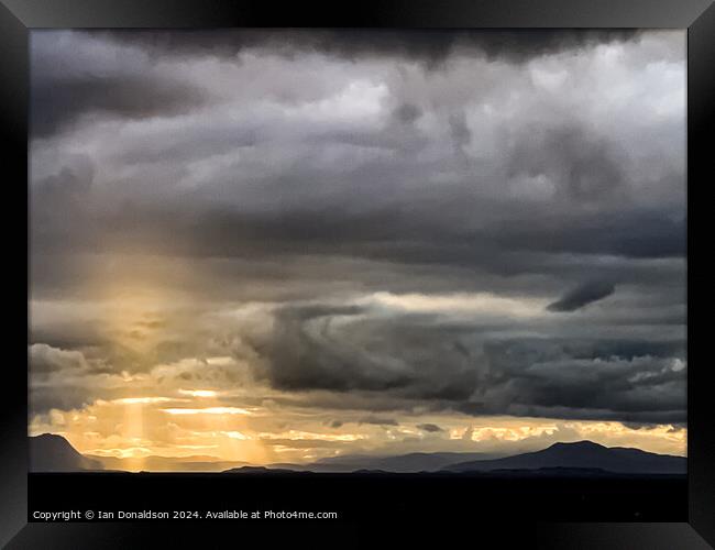 Sunlight Breaking Through a Stormy Scottish Sky Framed Print by Ian Donaldson