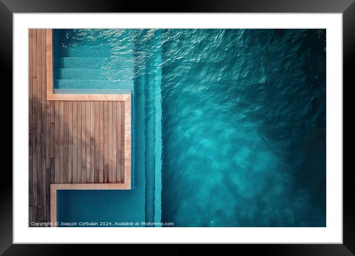 an aerial perspective of a swimming pool with a wooden deck. The pool is surrounded by the deck, providing ample space for relaxation and recreation. Framed Mounted Print by Joaquin Corbalan