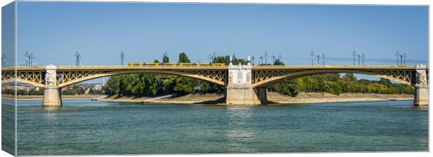 Yellow bridge with tram crossing over Danube River, Budapest, Hungary. Canvas Print by Maggie Bajada
