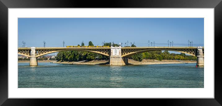 Yellow bridge with tram crossing over Danube River, Budapest, Hungary. Framed Mounted Print by Maggie Bajada