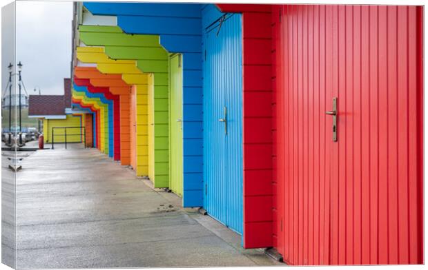 Colourful beach huts (de-focused near and far)  in a row on Scarborough North Bay Beach, Yorkshire, England Canvas Print by Dave Collins