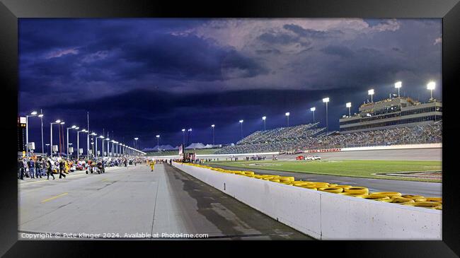 Storm clouds over a Speedway pit lane Framed Print by Pete Klinger