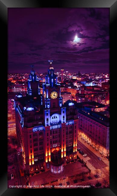 Moonlit cityscape with illuminated historic building at night, showcasing urban architecture against a dramatic sky in Liverpool, UK. Framed Print by Man And Life