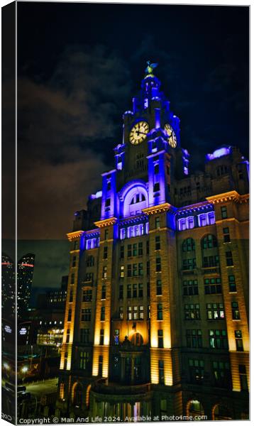 Liverpool's iconic Royal Liver Building at night, illuminated with blue lights against a dark sky. Canvas Print by Man And Life